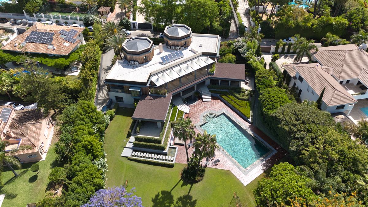 Aerial view of a villa with lawn and pool