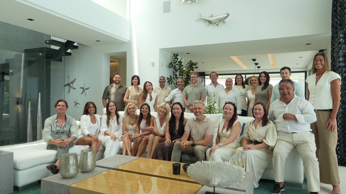 Full agency team gathered in a villa living room