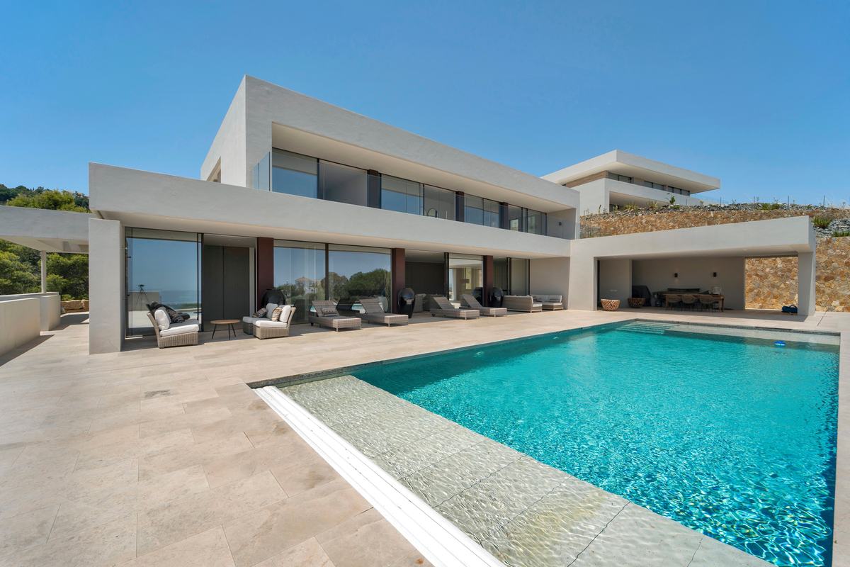 Contemporary villa and pool seen across a travertine terrace