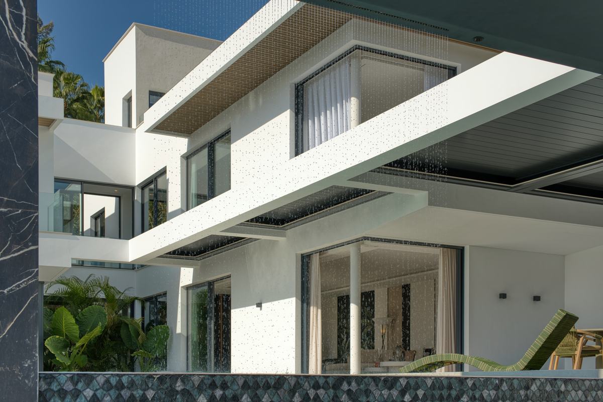 Contemporary villa facade behind a falling water curtain